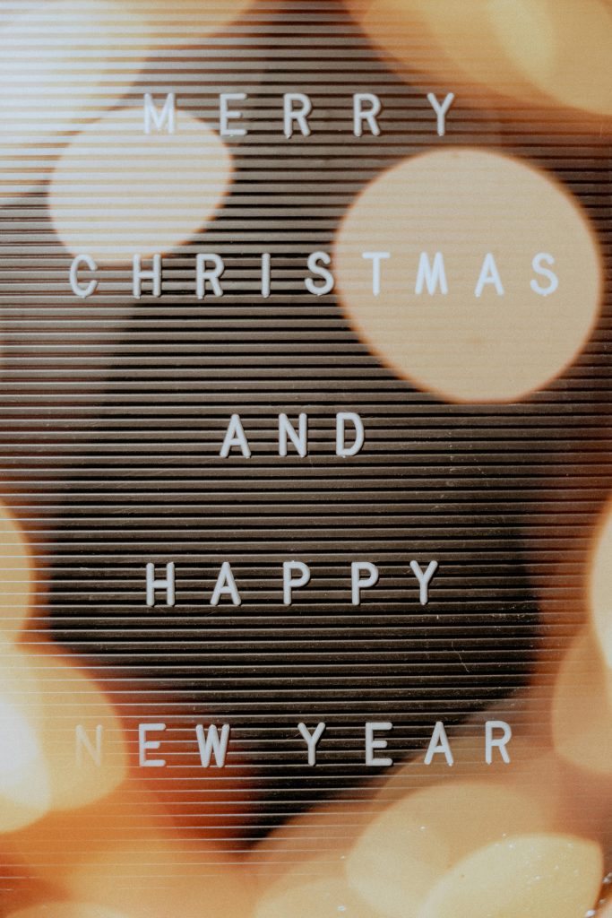 Christmas and New Year message on a festive bokeh background with warm tones.